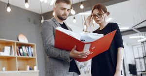 Two people reviewing documents in a red folder