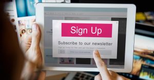 Person holding a tablet showing a newsletter sign-up form