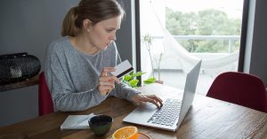 Woman reviewing a credit card account on a laptop while rebuilding credit