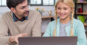 Father and daughter reviewing information on a laptop together