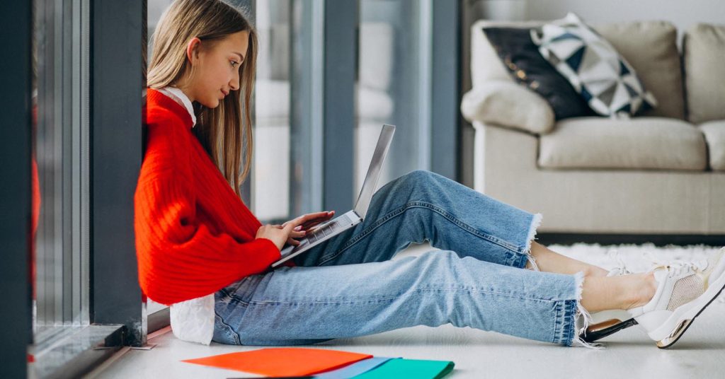 Woman working on a laptop at home while starting a freelance business