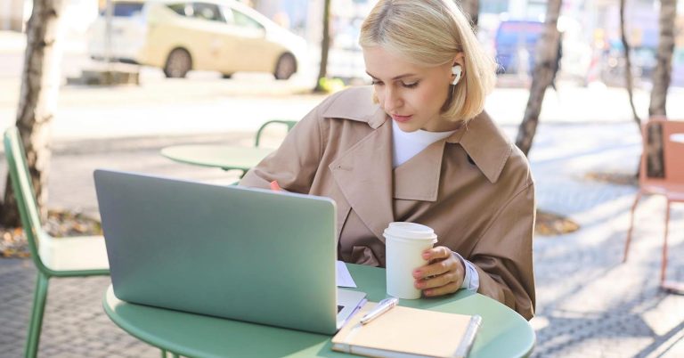 Freelancer preparing a client proposal on a laptop at an outdoor table