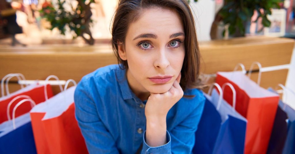 Woman sitting among shopping bags after shopping