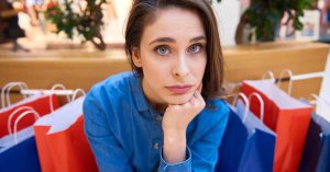 Woman sitting among shopping bags after shopping