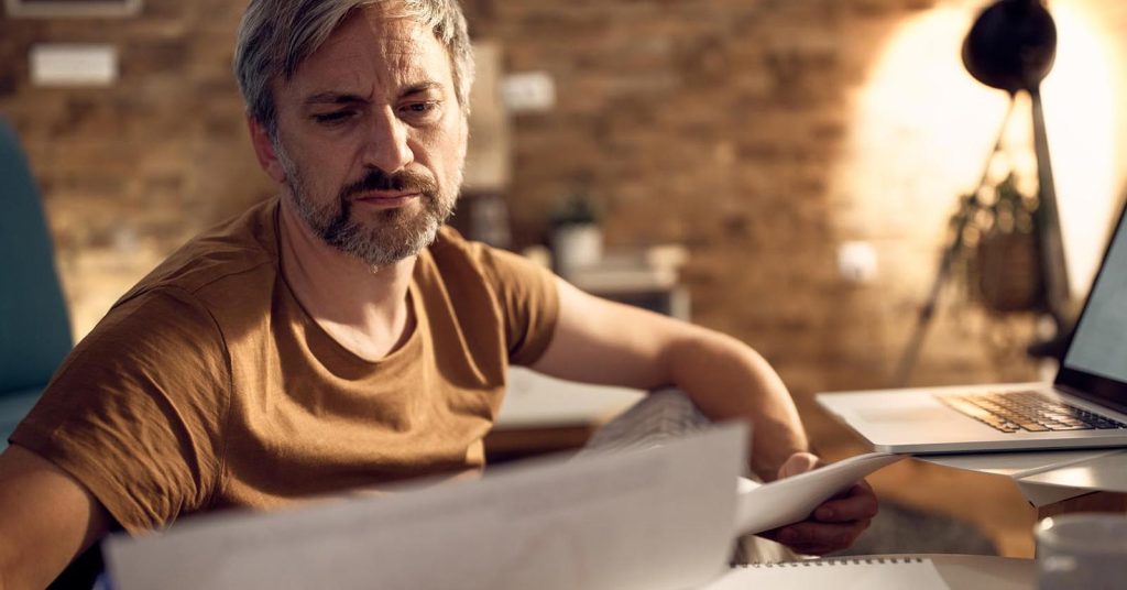 Man reviewing financial documents before retirement