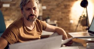 Man reviewing financial documents before retirement