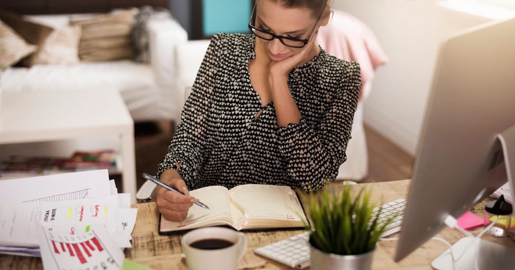 Woman comparing personal loan and balance transfer offers while reviewing financial charts