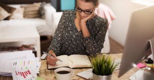 Woman comparing personal loan and balance transfer offers while reviewing financial charts
