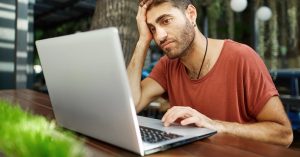 Man reviewing information on a laptop with a concerned expression
