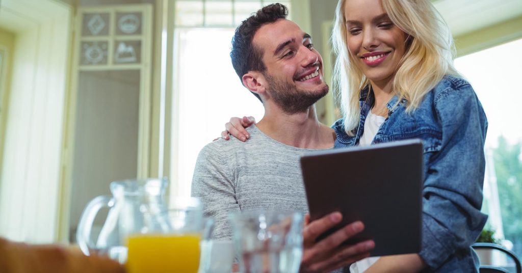 Couple looking at a tablet together at home