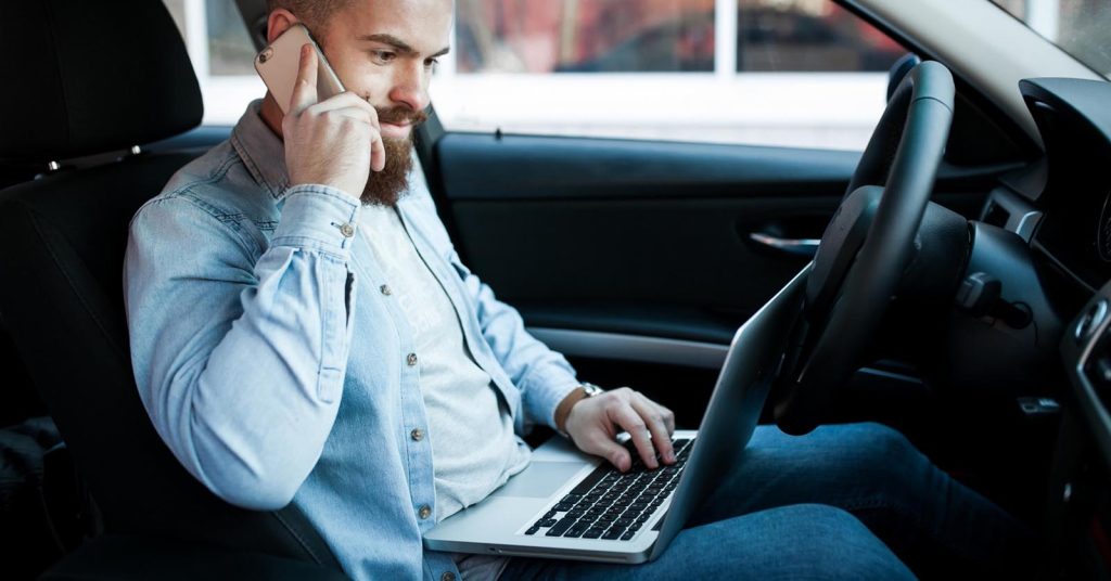 Gig driver reviewing rideshare and delivery earnings while parked in a car