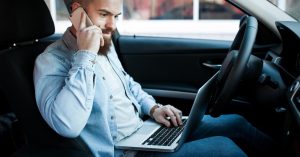 Gig driver reviewing rideshare and delivery earnings while parked in a car