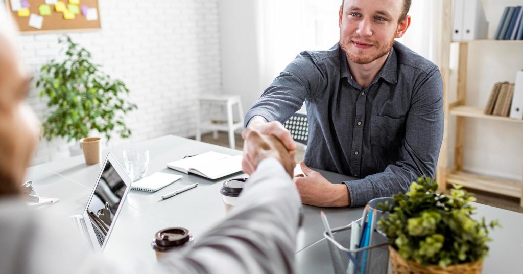 Job candidate shaking hands with an employer after discussing a job offer