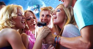 Friends singing karaoke together at a party