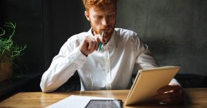 Man reviewing notes and calculations while planning his finances