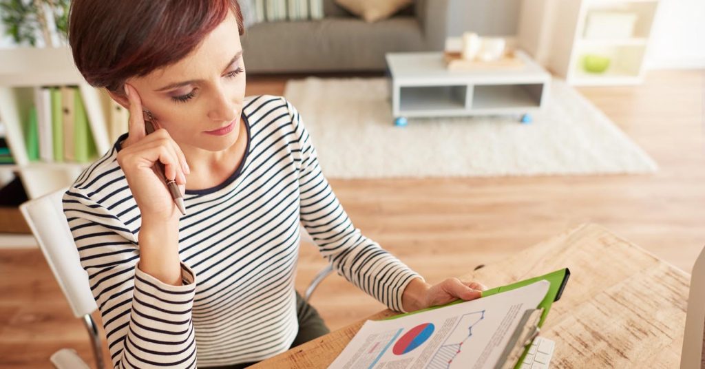 Woman reviewing financial charts and planning future goals at home