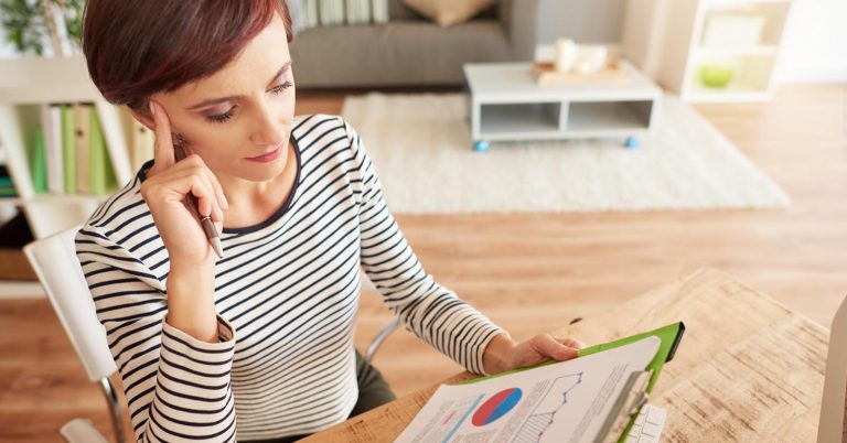 Woman reviewing financial charts and planning future goals at home