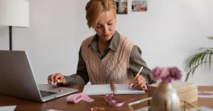 Woman tracking side hustle income and expenses while working from home
