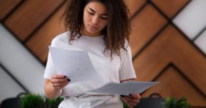 Woman comparing several debt statements to determine which accounts may be settled