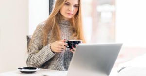 Woman using a laptop while reviewing personal financial information