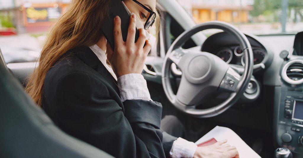 Driver reviewing claim documents while speaking with an insurance company