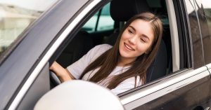Young woman sitting in the driver's seat of a car