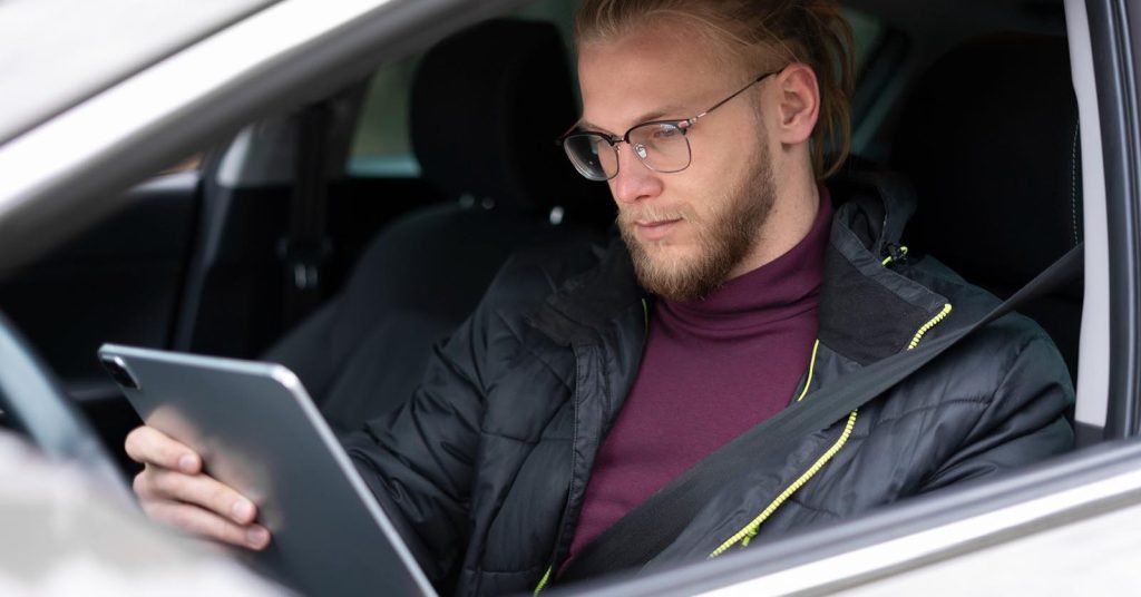 Driver checking car insurance information on a tablet