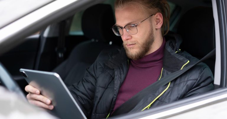 Driver checking car insurance information on a tablet