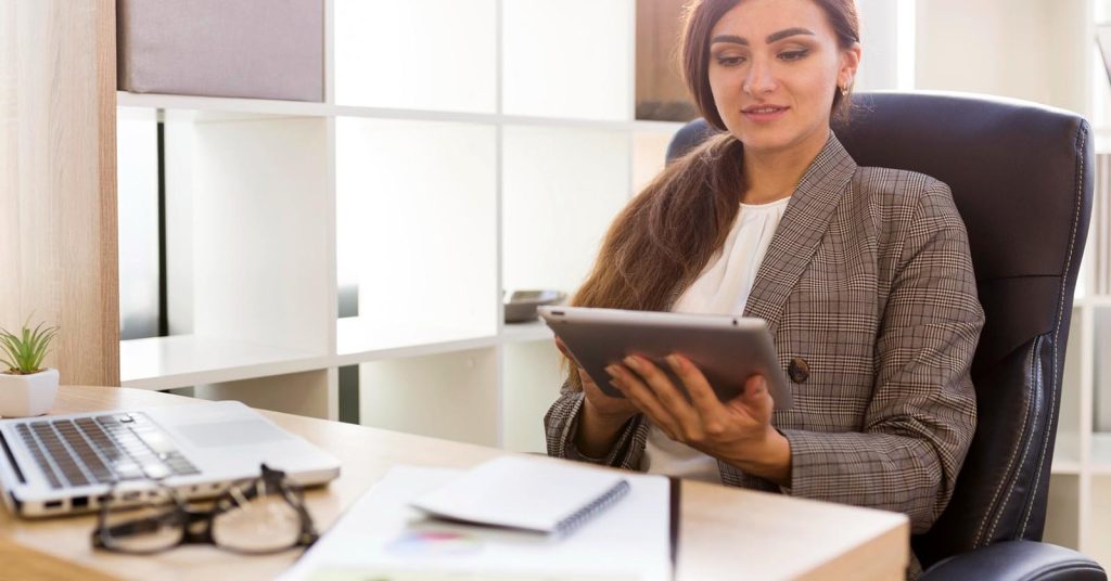 Woman reviewing information on a tablet at a desk