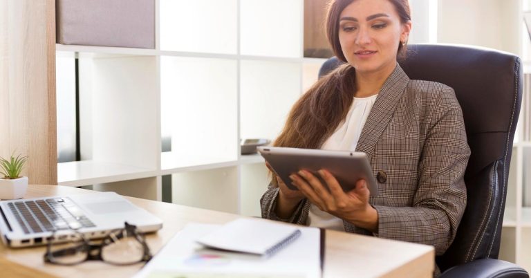 Woman reviewing information on a tablet at a desk