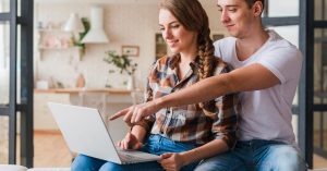 Young couple reviewing information together on a laptop at home