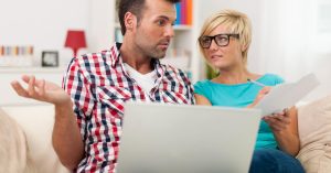 Couple reviewing household bills with a laptop