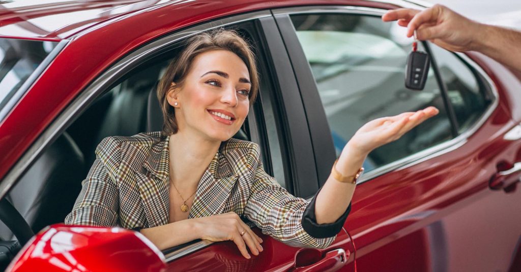 Woman receiving keys for a rental car