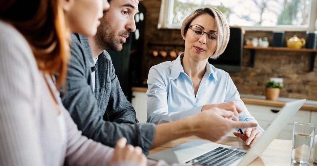 Couple discussing financial options with an adviser at a table