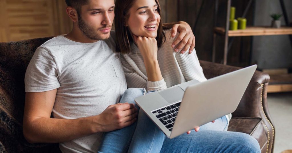 Couple reviewing information together on a laptop at home